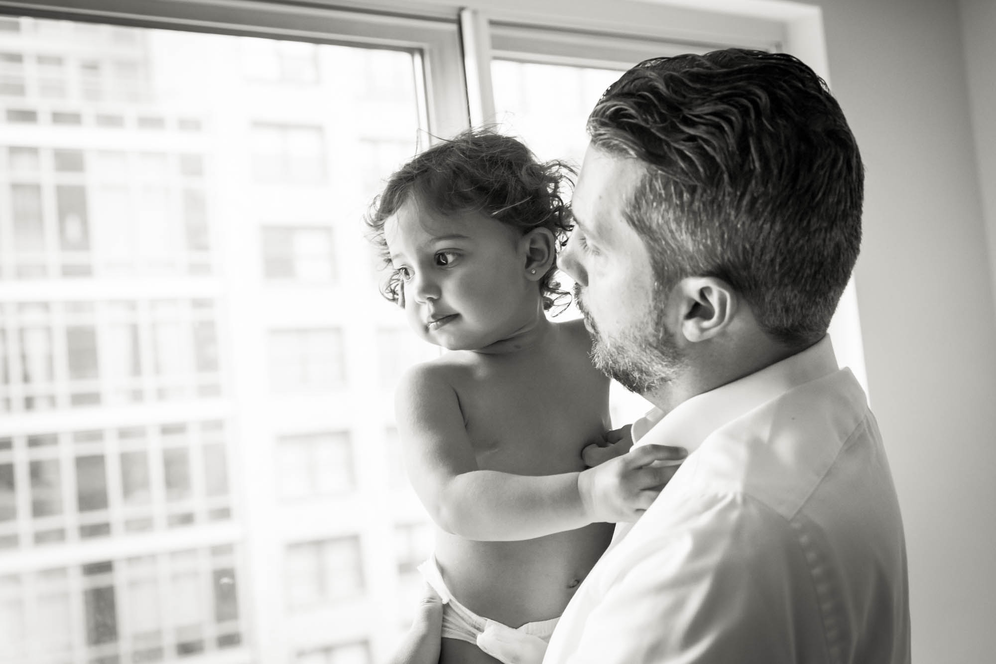 Manhattan family portrait session of father holding toddler in front of window