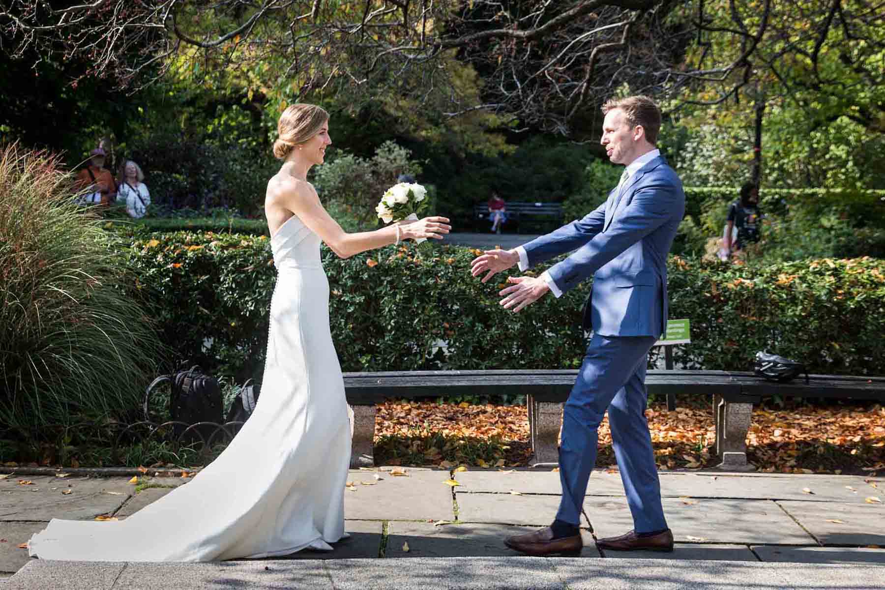 Conservatory Garden wedding photos of bride and groom reaching for each other during first look