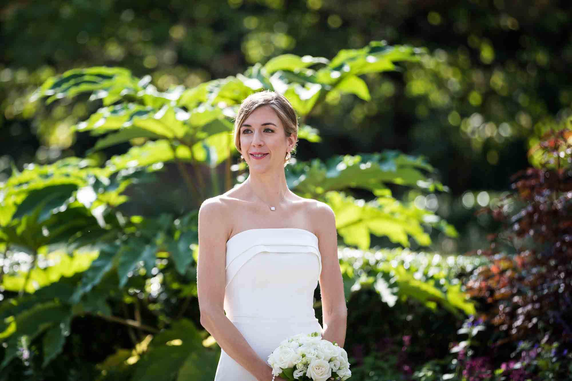 Conservatory Garden wedding photos of bride wearing strapless white dress looking for groom