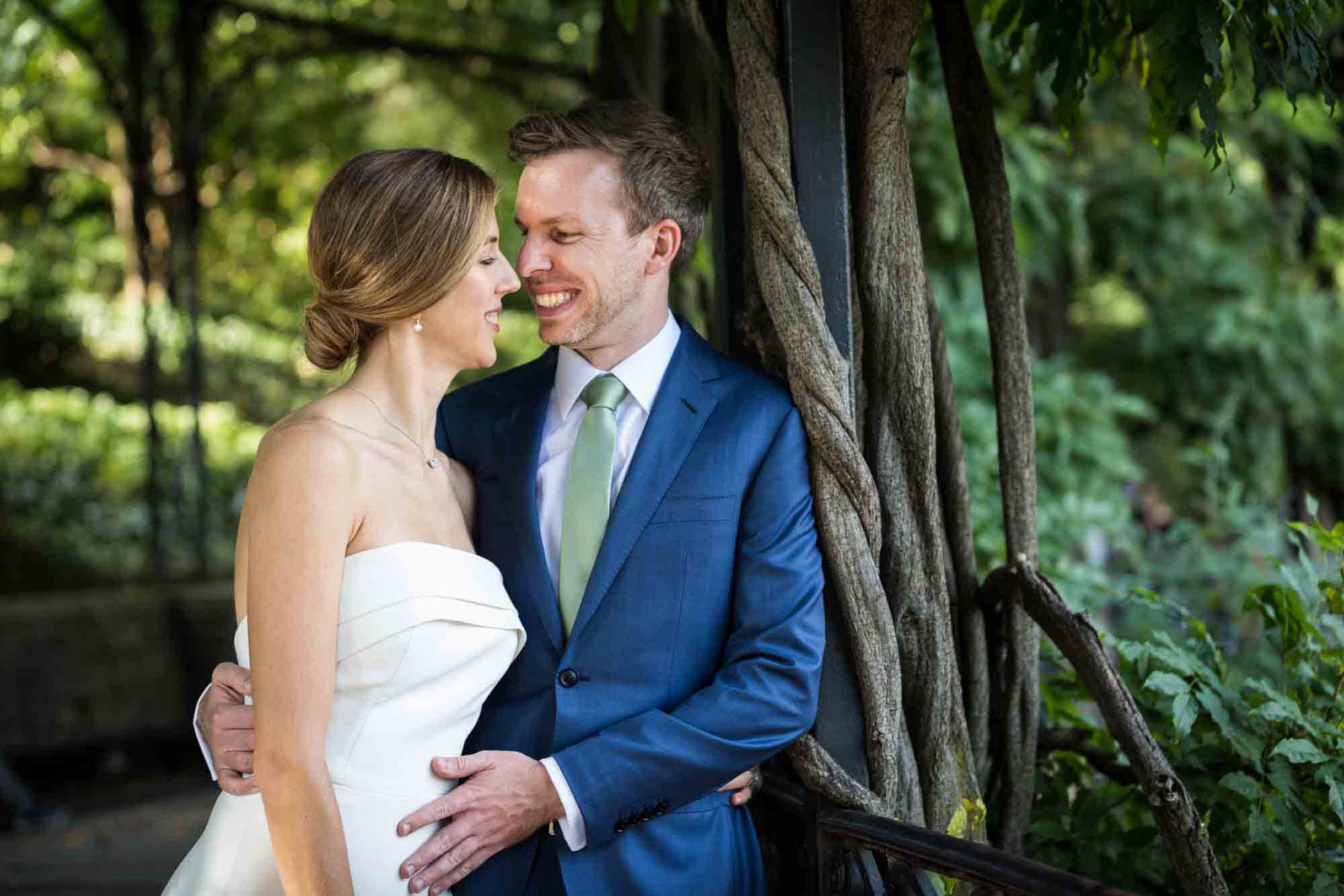 Couple cuddling on Wisteria Terrace during a Conservatory Garden wedding in Central Park