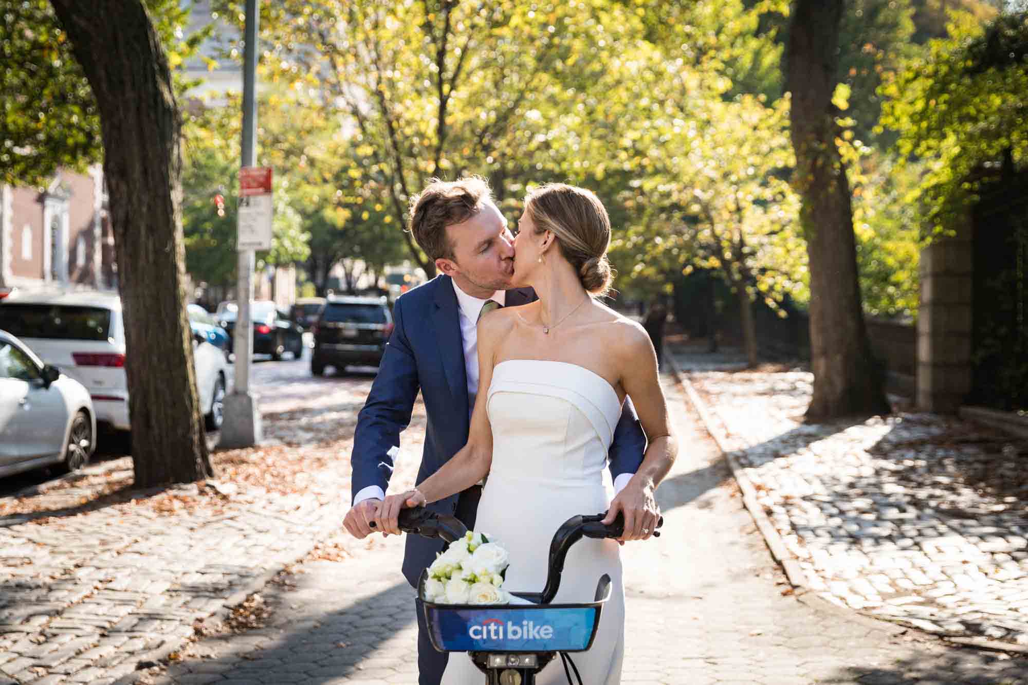 Conservatory Garden wedding photos of bride and groom kissing while on back of Citi Bike