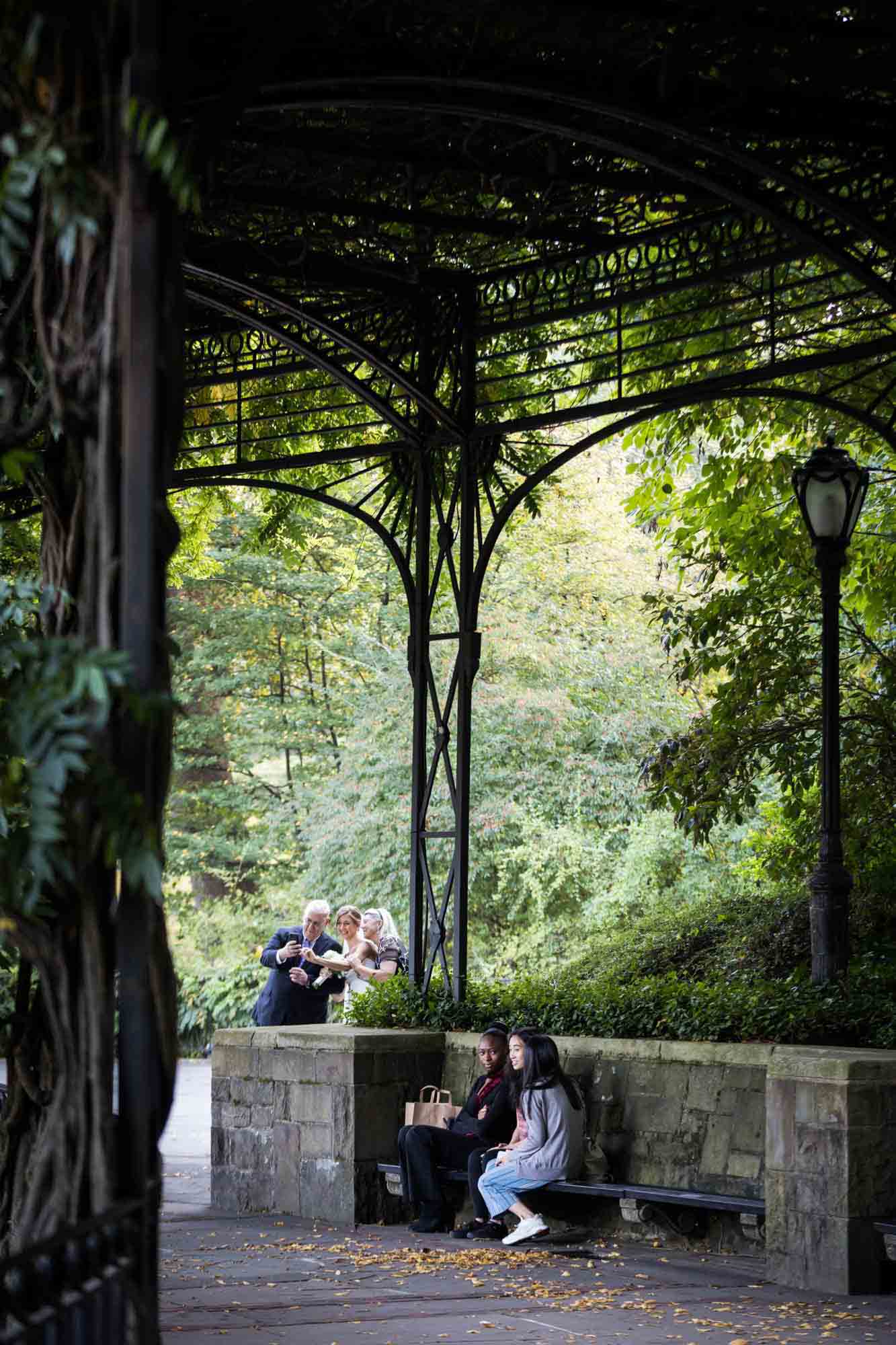 Park visitors sitting on bench during a Conservatory Garden wedding in Central Park