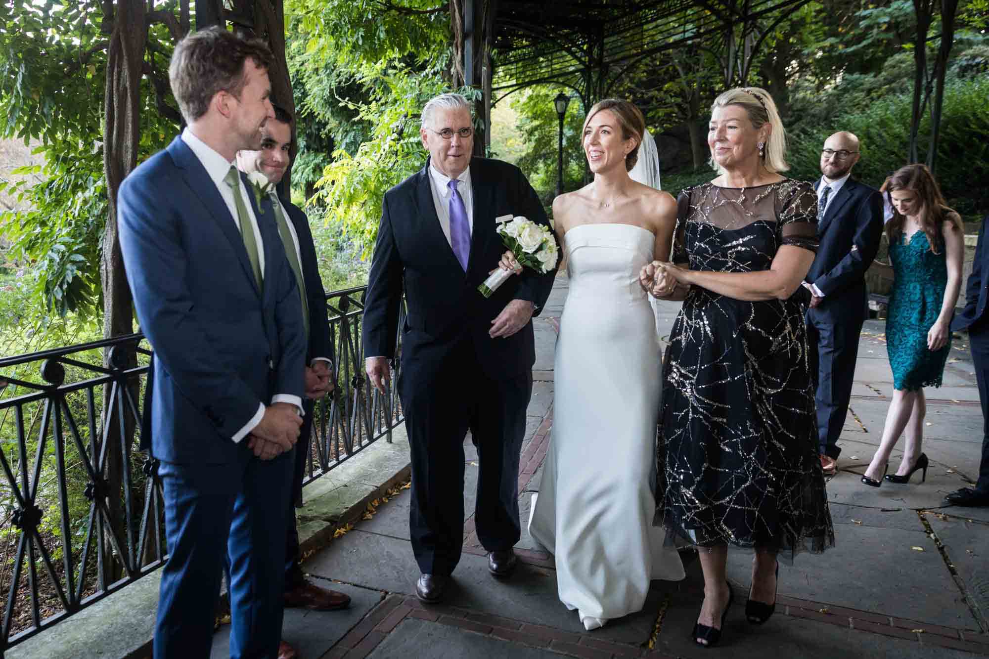 Bride and parents greeting groom on Wisteria Terrace during a Conservatory Garden wedding in Central Park