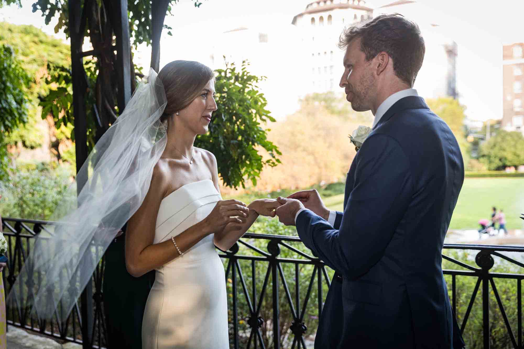 Bride and groom exchanging rings during a Conservatory Garden wedding in Central Park