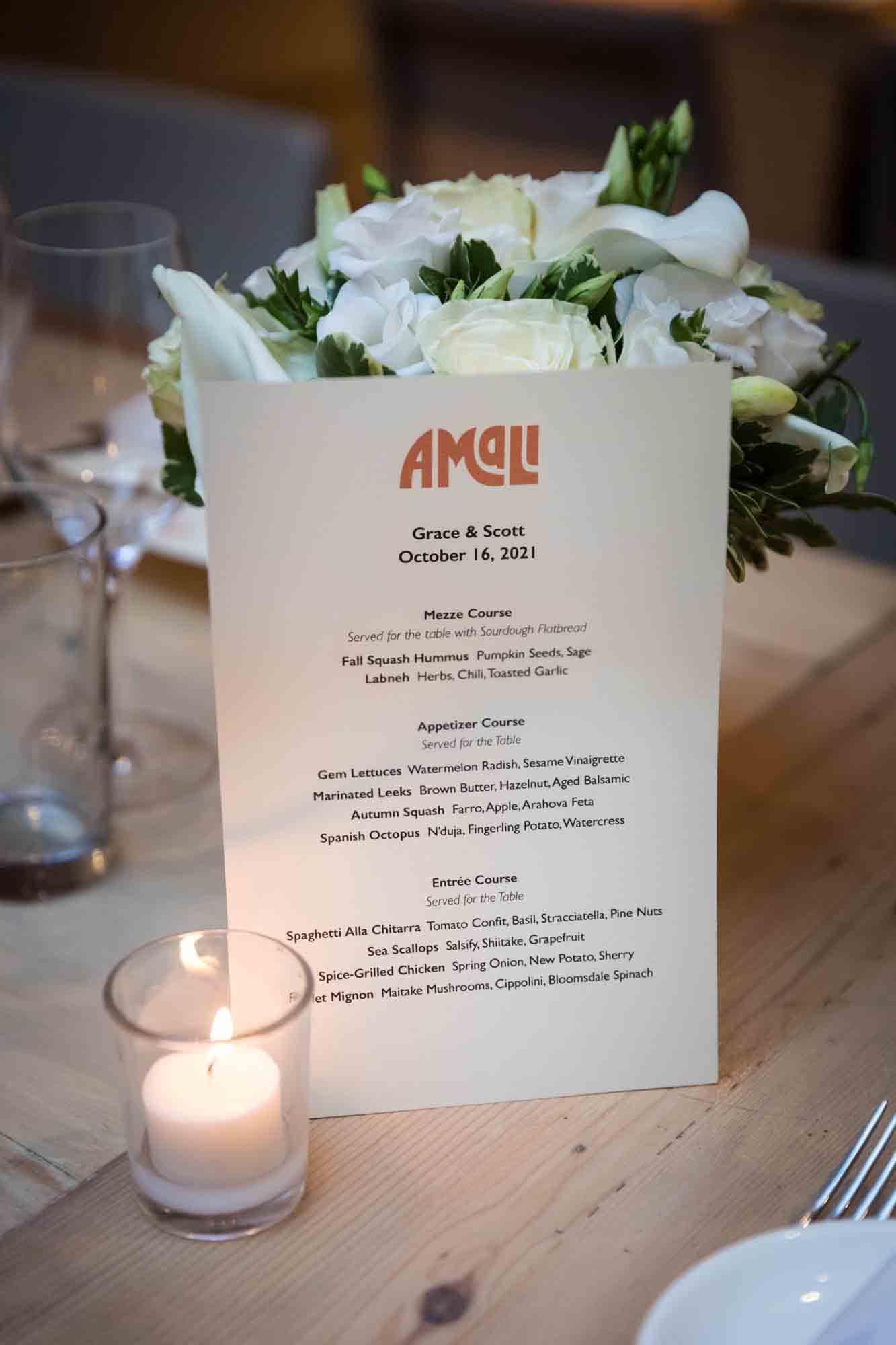 Menu card in front of flower centerpiece on table at Amali Restaurant