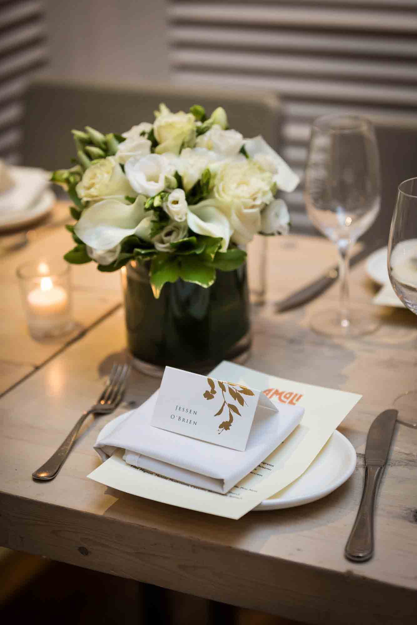 Place setting with white and yellow flower centerpiece in Amali restaurant