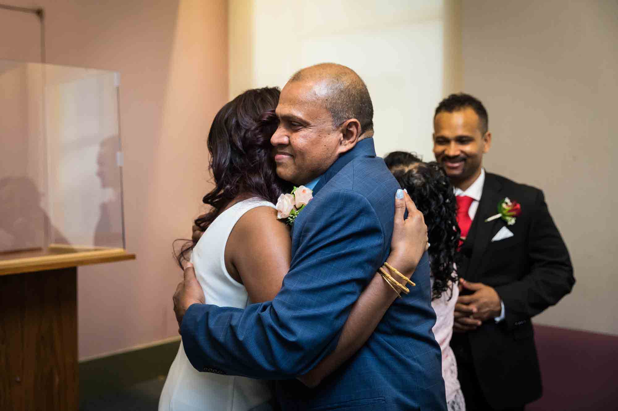 Bride hugging older man  at a NYC City Hall wedding