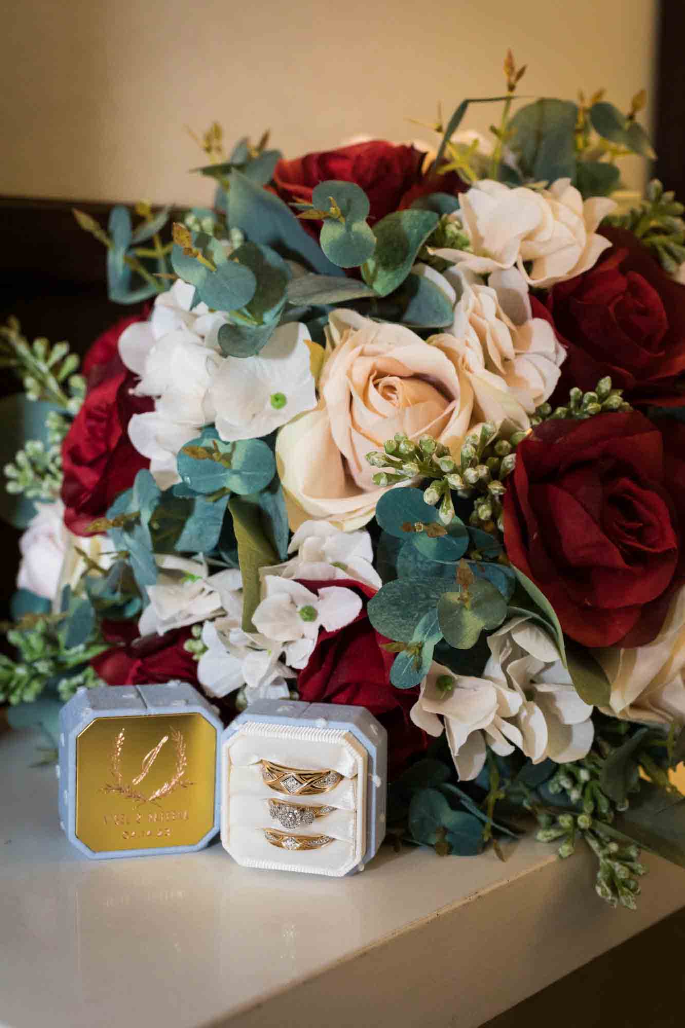 Floral bouquet and ring bow showing wedding rings on counter