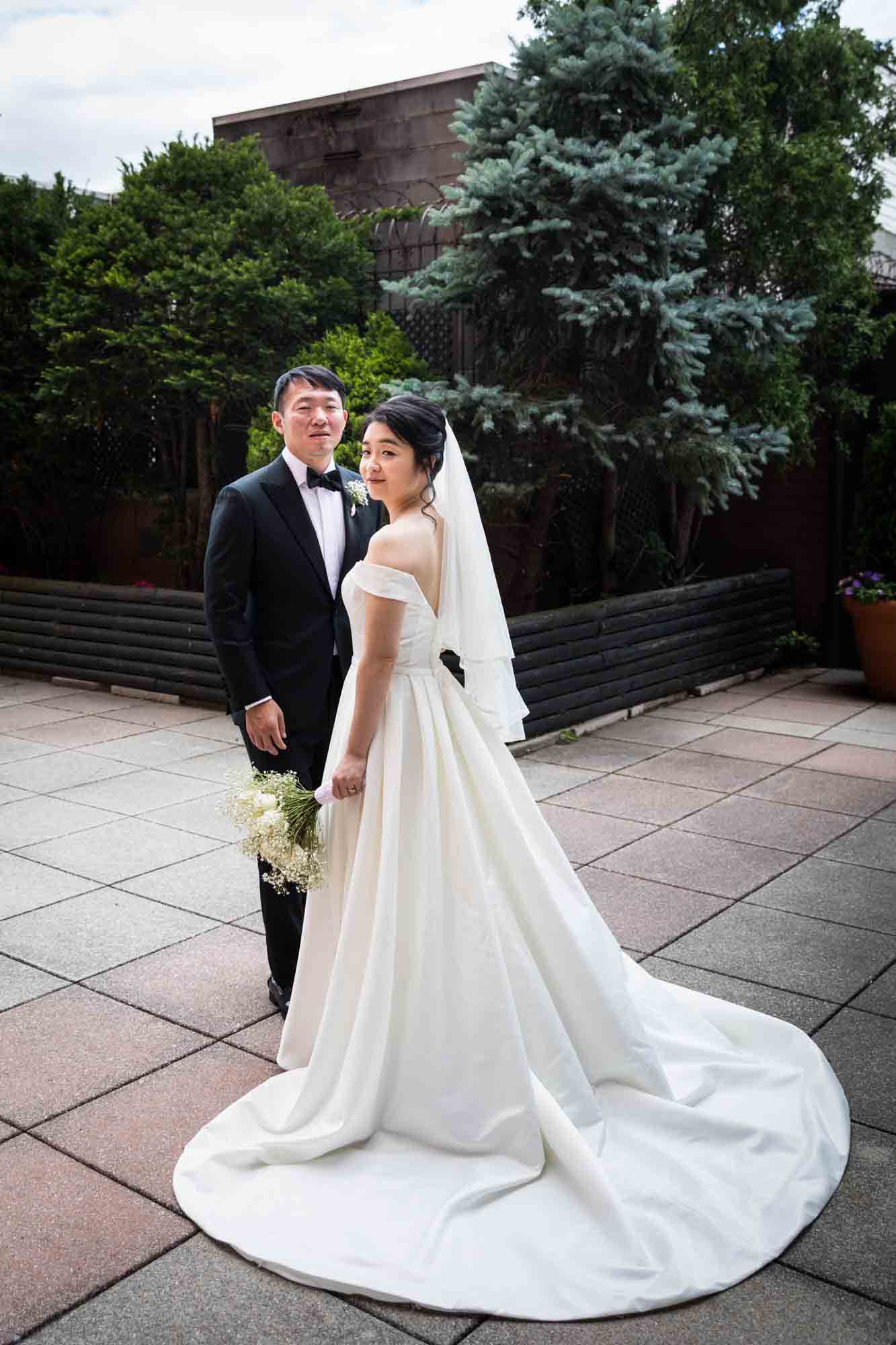 Full length photo of bride and groom standing together on outdoor patio at a Sheraton LaGuardia East Hotel wedding