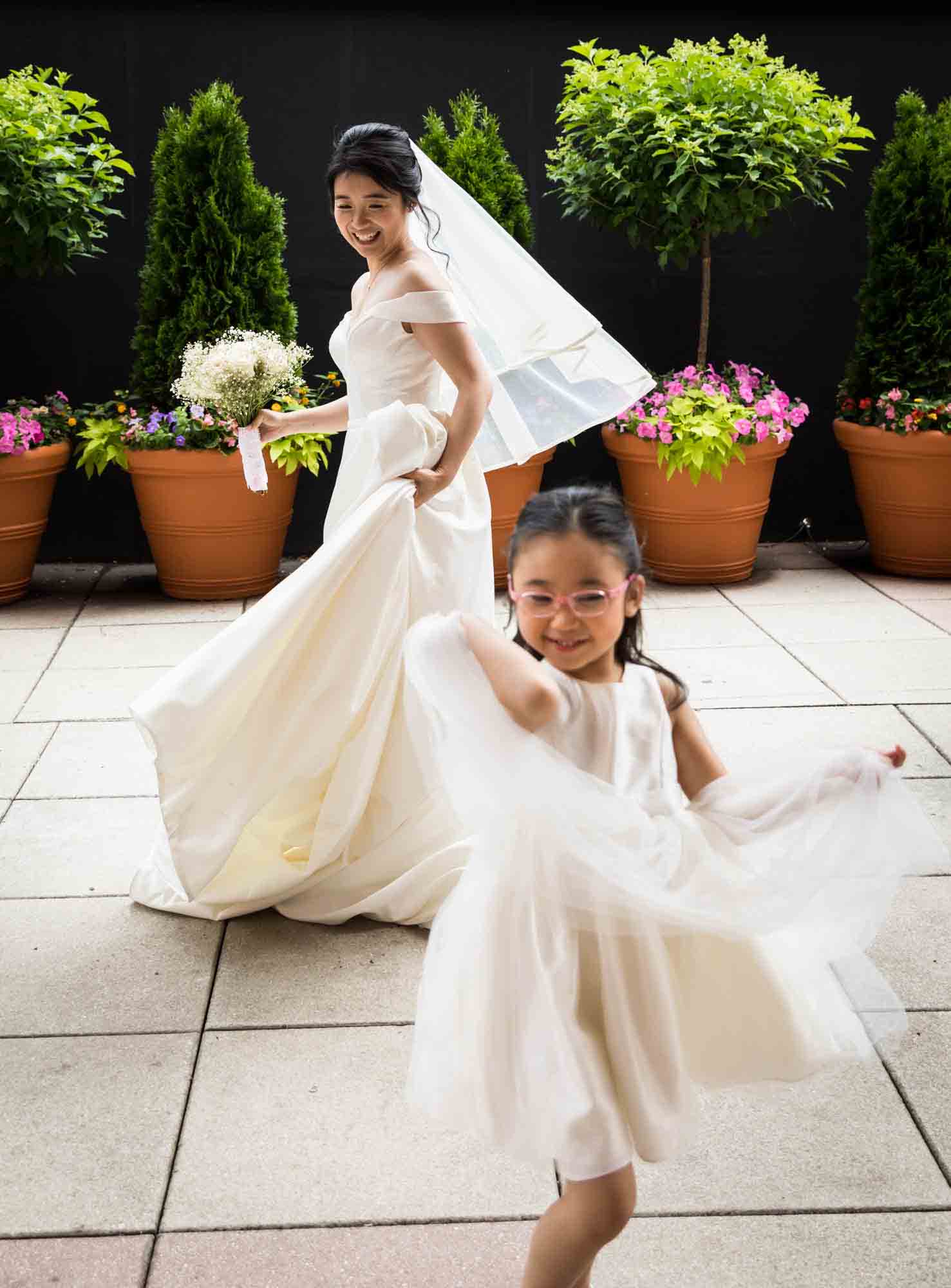 Bride and little girl dancing on outdoor patio at a Sheraton LaGuardia East Hotel wedding