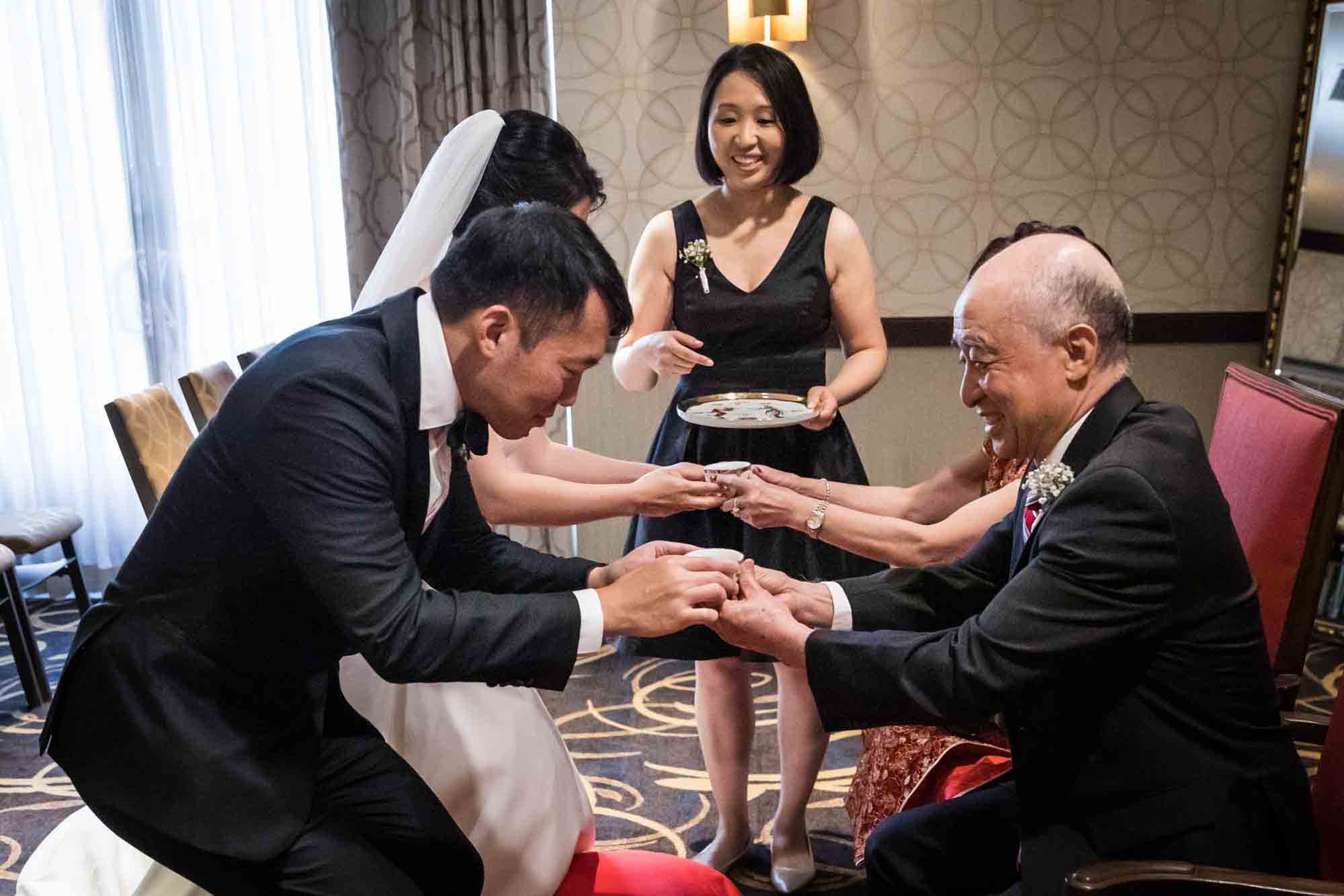 Bride and groom bestowing tea on parents during tea ceremony at a Sheraton LaGuardia East Hotel wedding