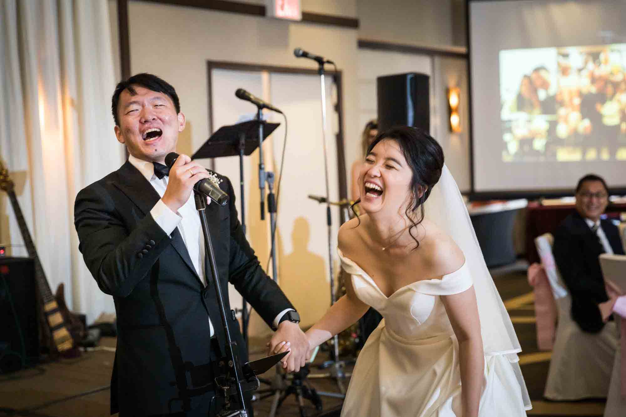 Bride and groom laughing in front of band at a Sheraton LaGuardia East Hotel wedding