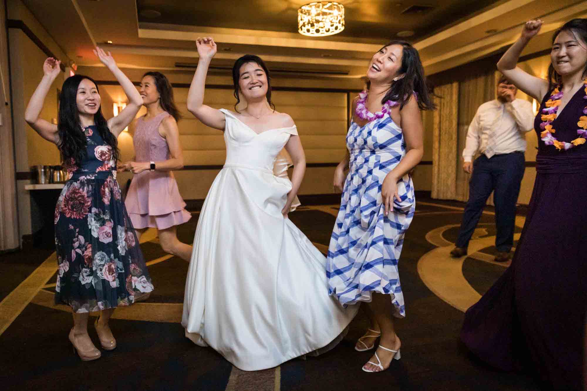 Bride dancing with two female guests at a Sheraton LaGuardia East Hotel wedding