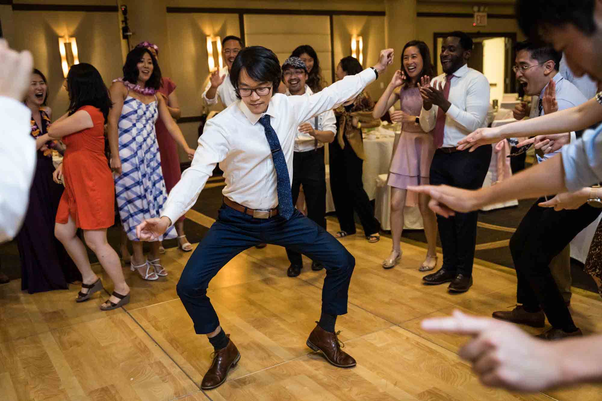 Man dancing with knees akimbo at a Sheraton LaGuardia East Hotel wedding
