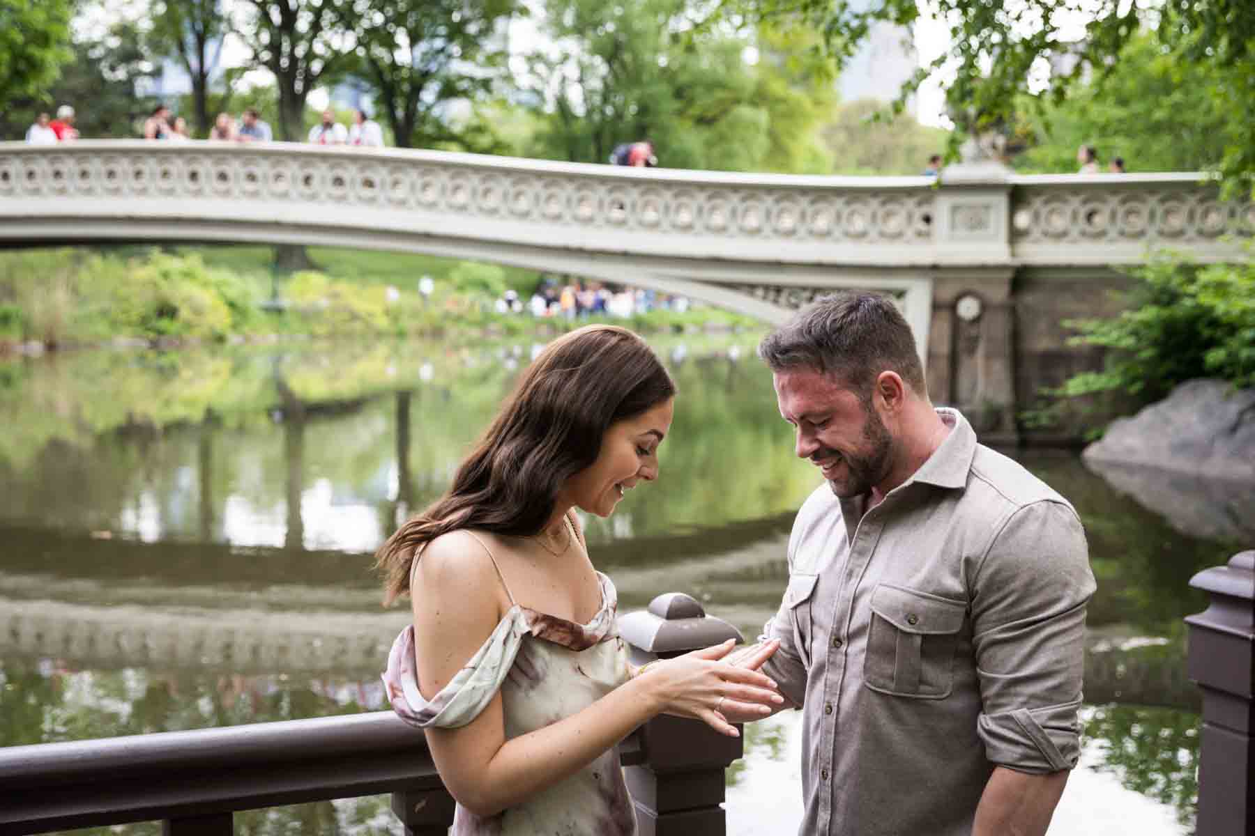 Woman looking at engagement ring on finger during a Central Park surprise proposal