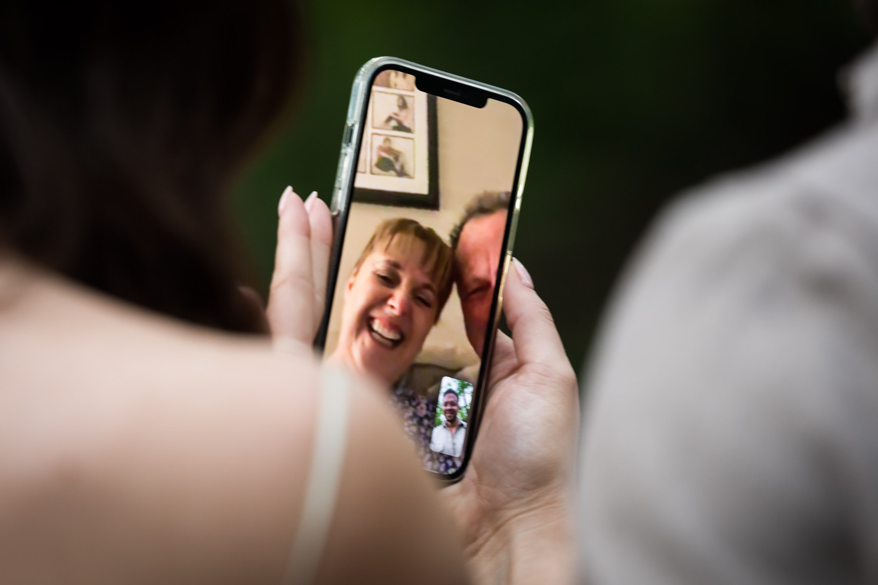 Cell phone showing excited parents Woman looking at engagement ring on finger during a Central Park surprise proposal