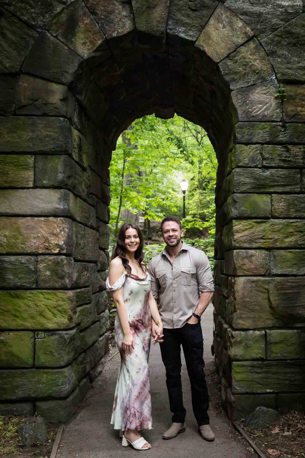 Couple standing in stone archway for an article on the best places to propose in Central Park
