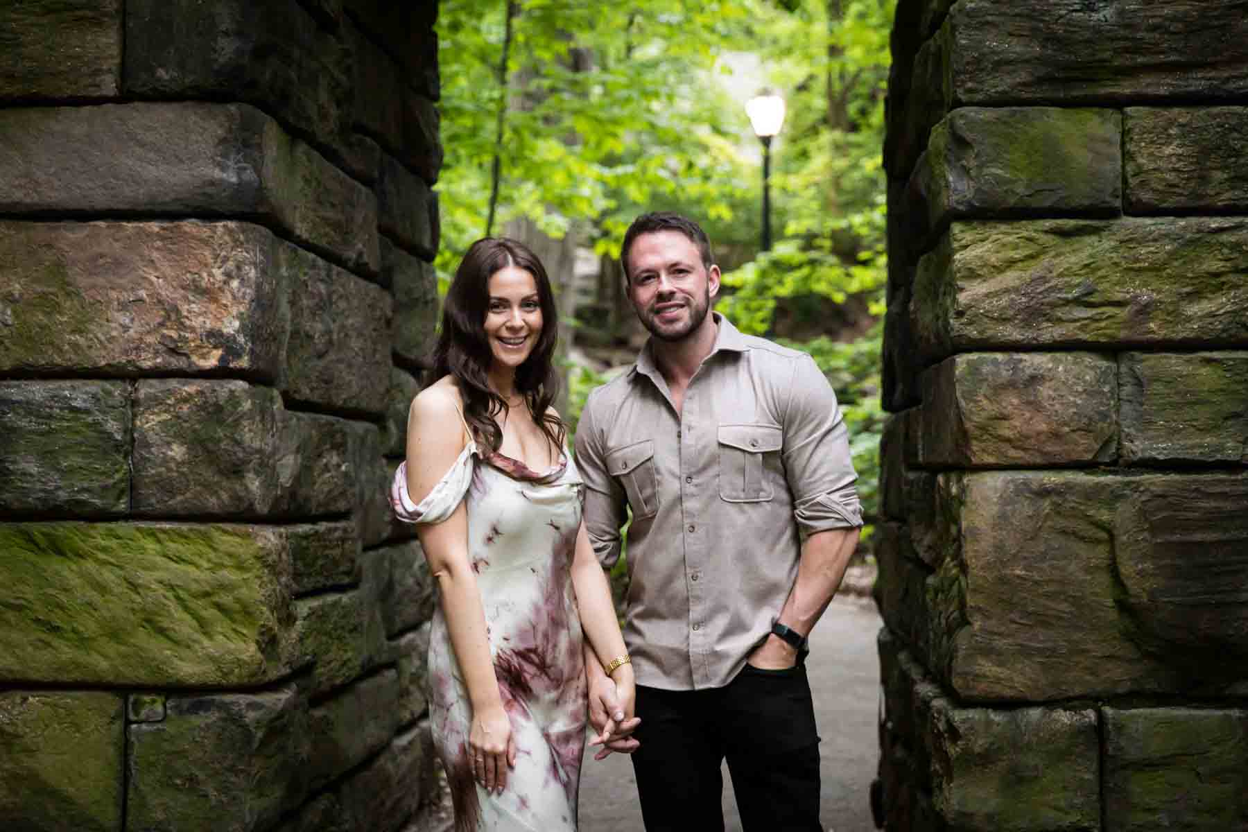 Couple standing in stone archway for an article on the best places to propose in Central Park 