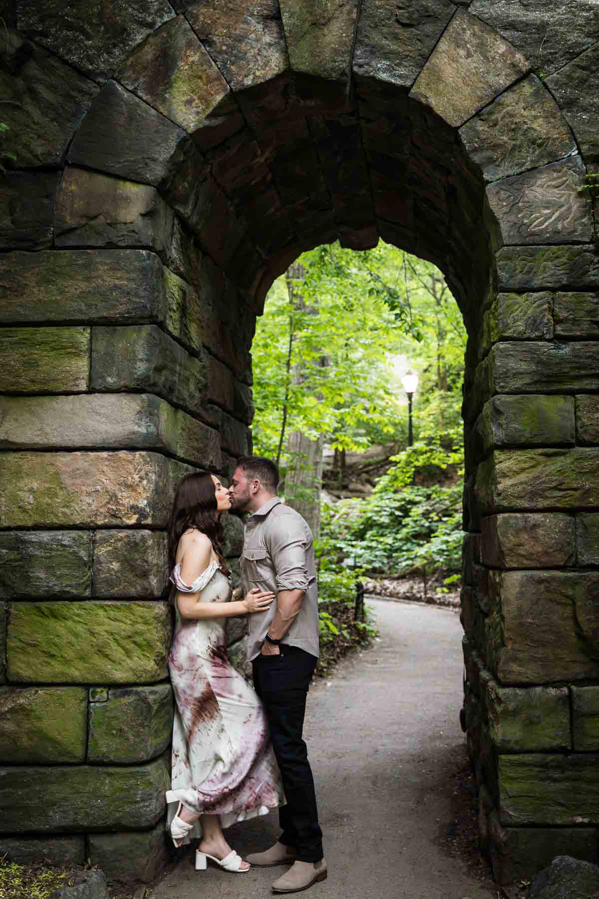 Couple kissing in stone archway for an article on the best places to propose in Central Park