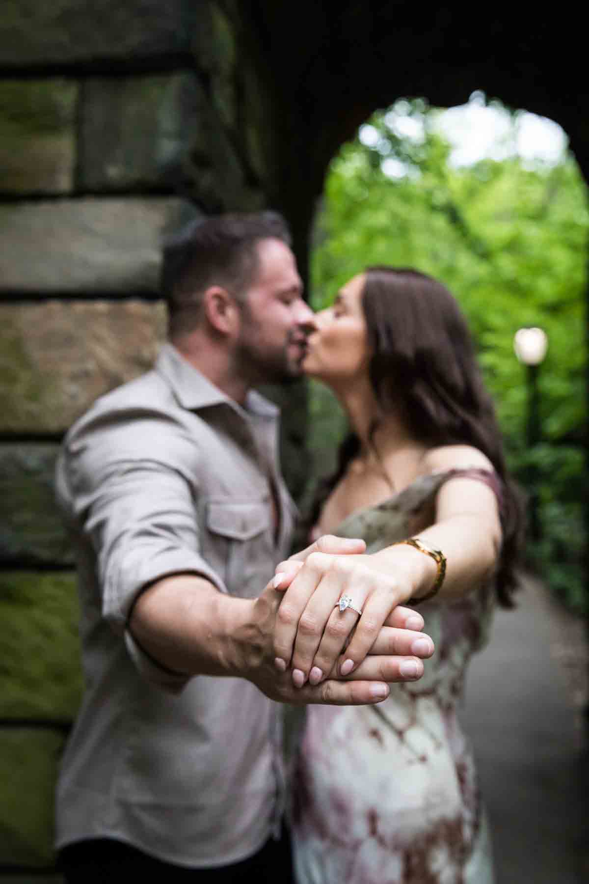 Couple standing in stone archway showing engagement ring for an article on the best places to propose in Central Park