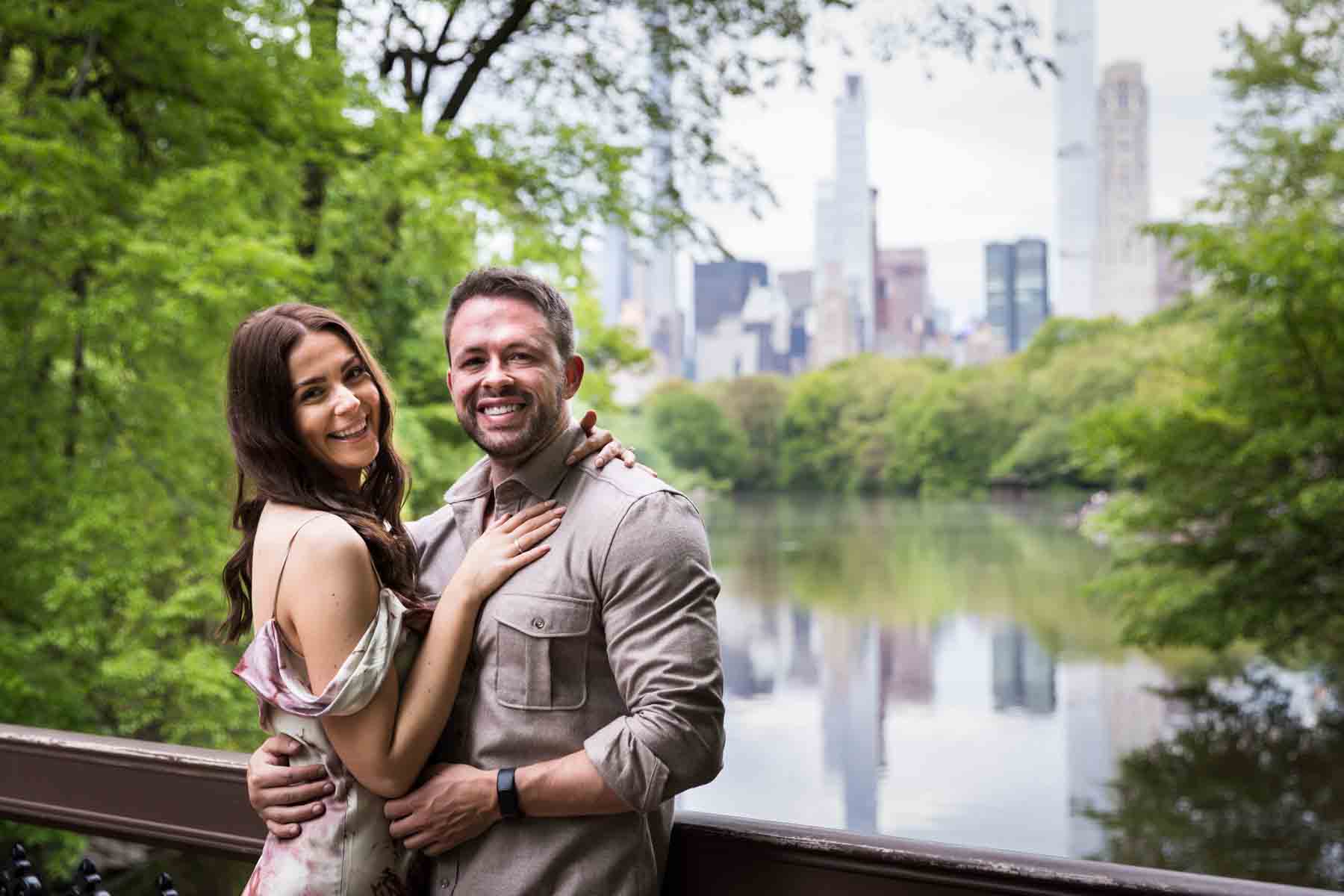 Couple standing against oak bridge for an article on the best places to propose in Central Park