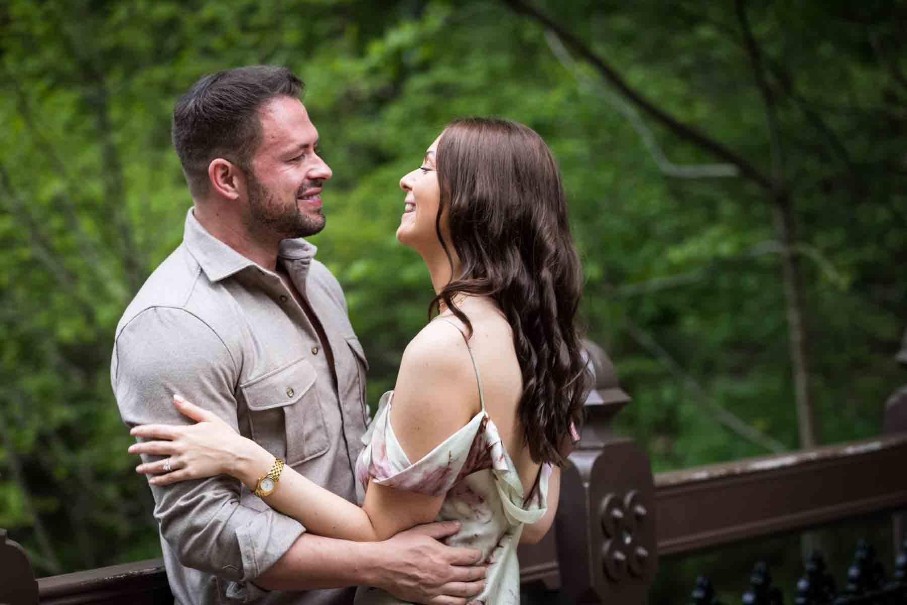 Couple standing against oak bridge for an article on the best places to propose in Central Park