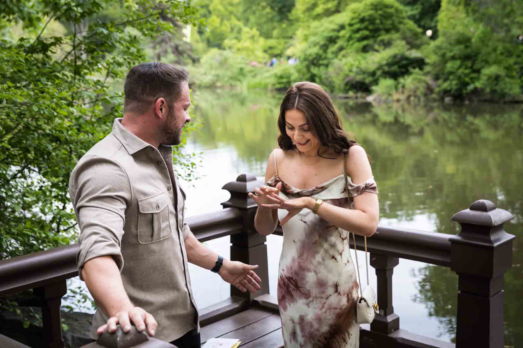 Woman looking at engagement ring on finger during a Central Park surprise proposal