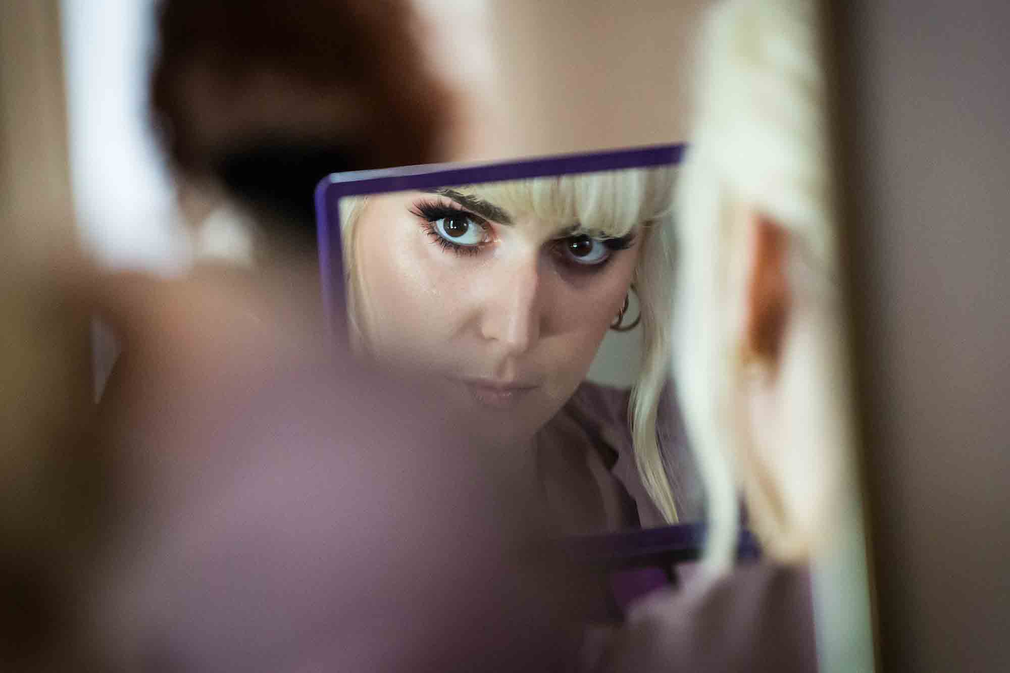 Reflection in mirror of female guest with blond hair