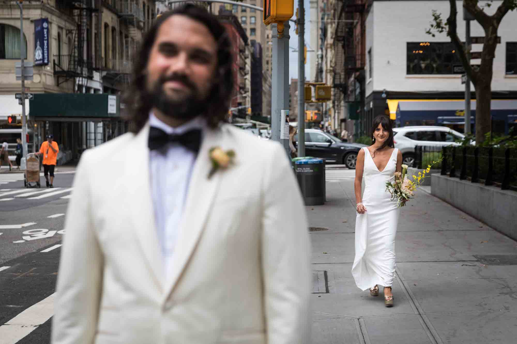 Bride walking up to groom on NYC sidewalk for first look