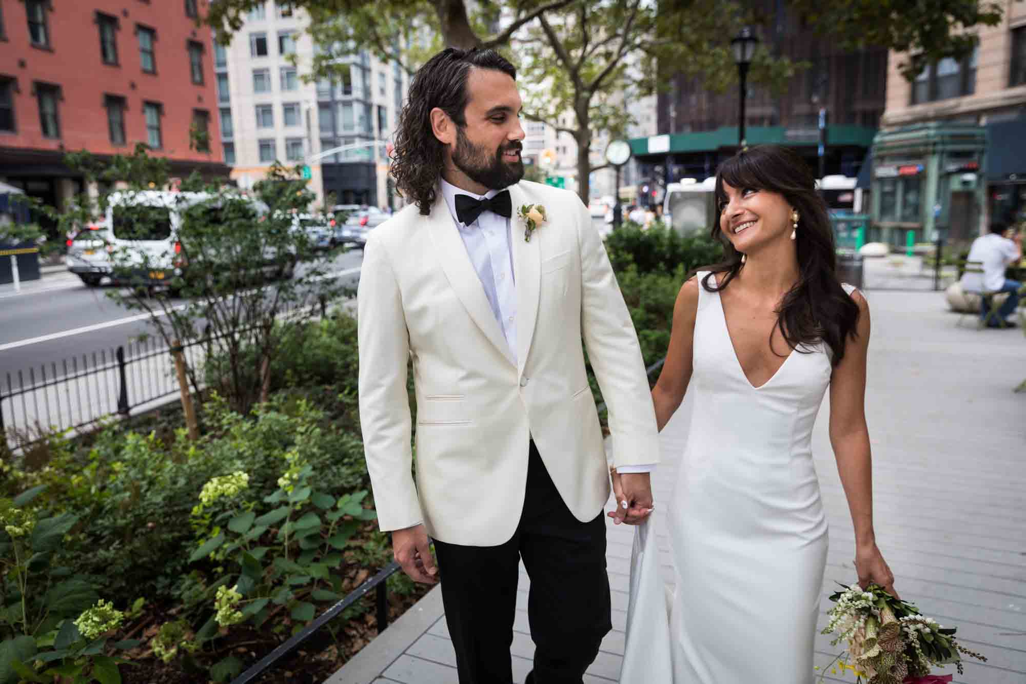 Bride and groom walking on platform in NYC park