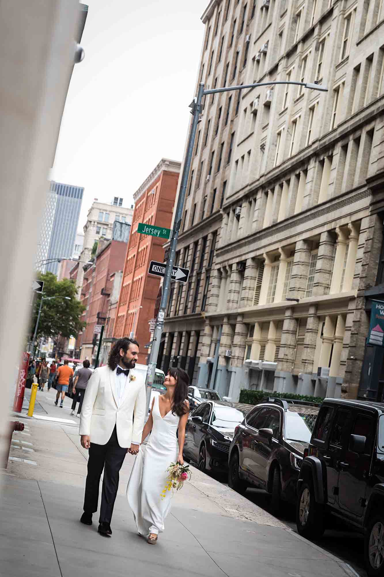 Bride and groom walking down Crosby Street on sidewalk in NYC