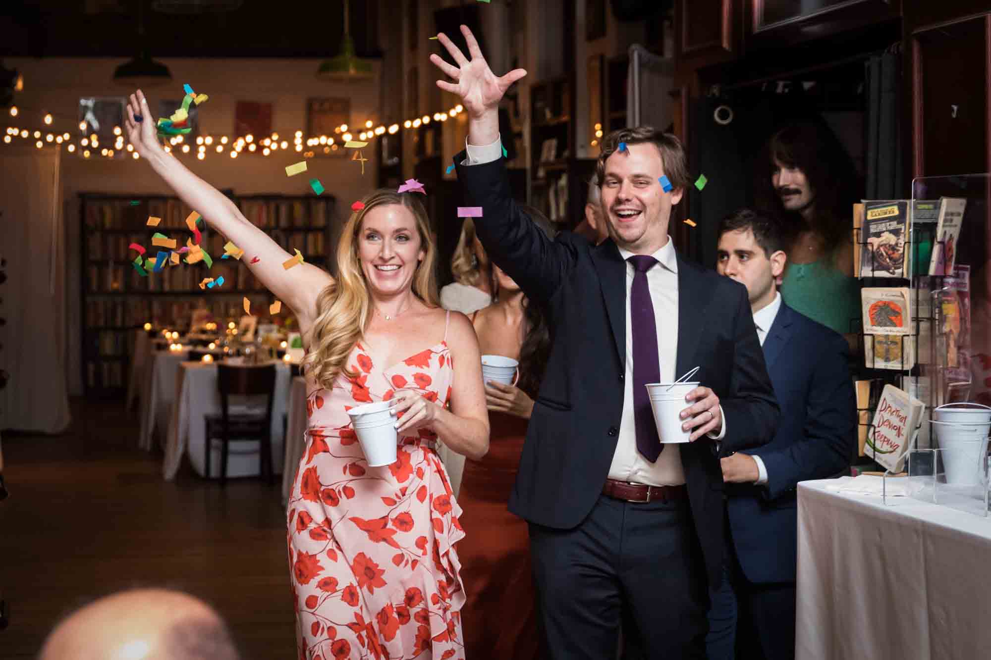 Guests walking down aisle throwing colorful confetti in the air at a Housing Works wedding