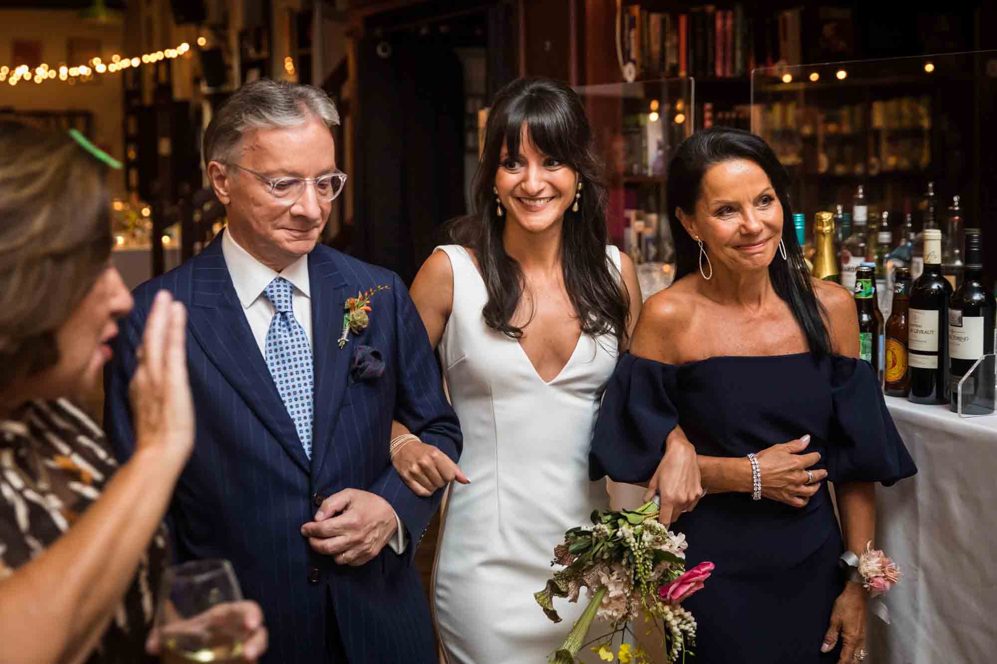 Bride being escorted by mother and father down the aisle at a Housing Works wedding