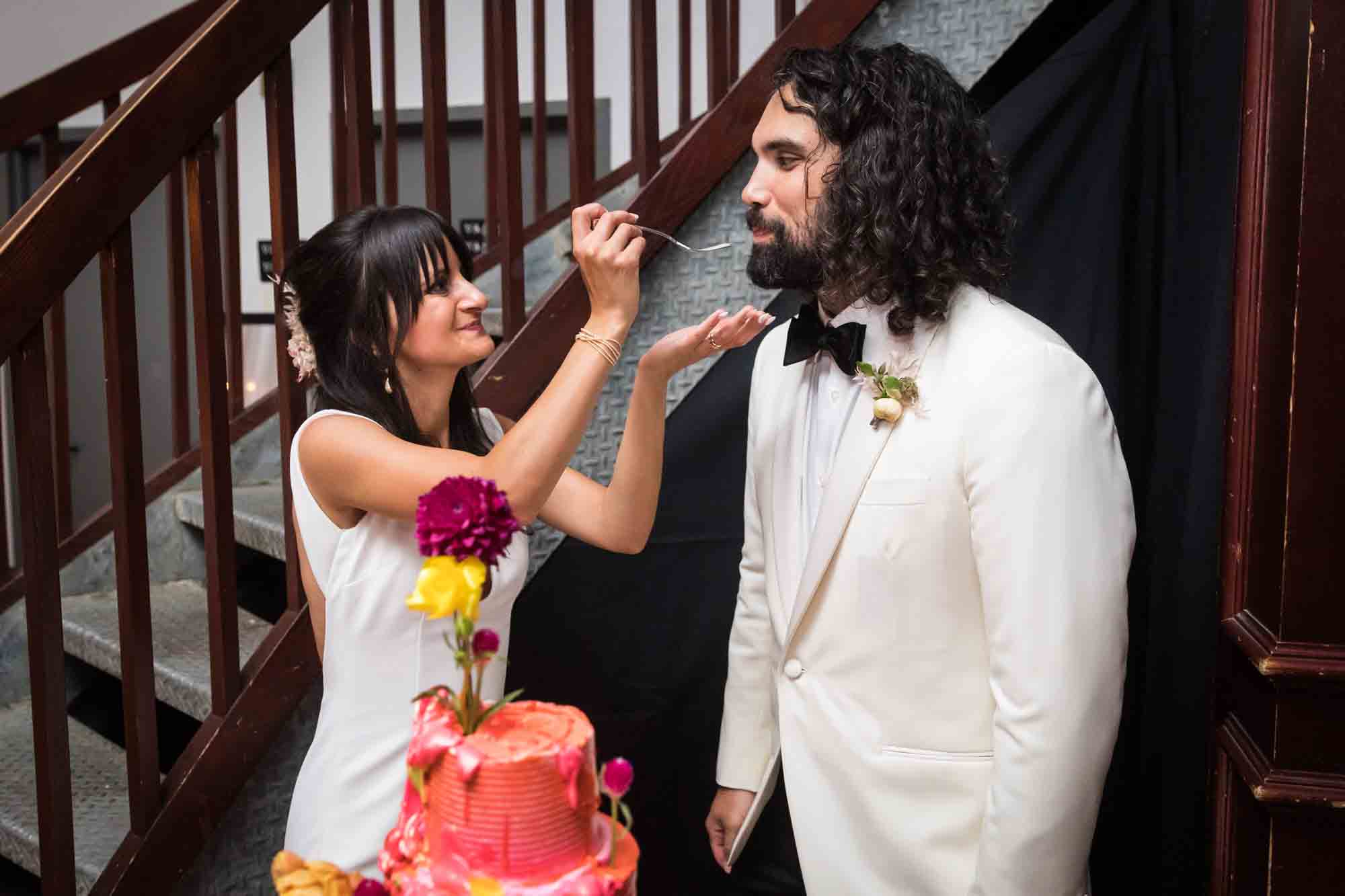 Bride feeding cake to groom at a Housing Works wedding