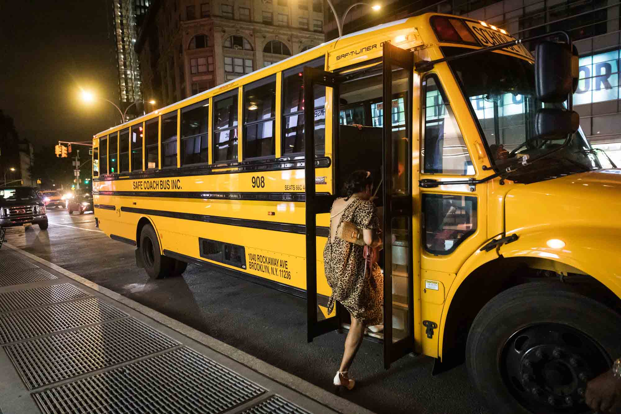 Guest wearing leopard dress getting on school bus at night