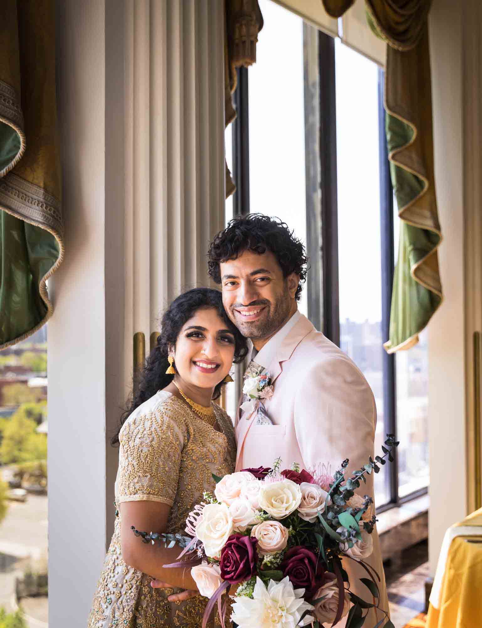 Indian bride and groom standing in front of window and column during a Terrace on the Park wedding