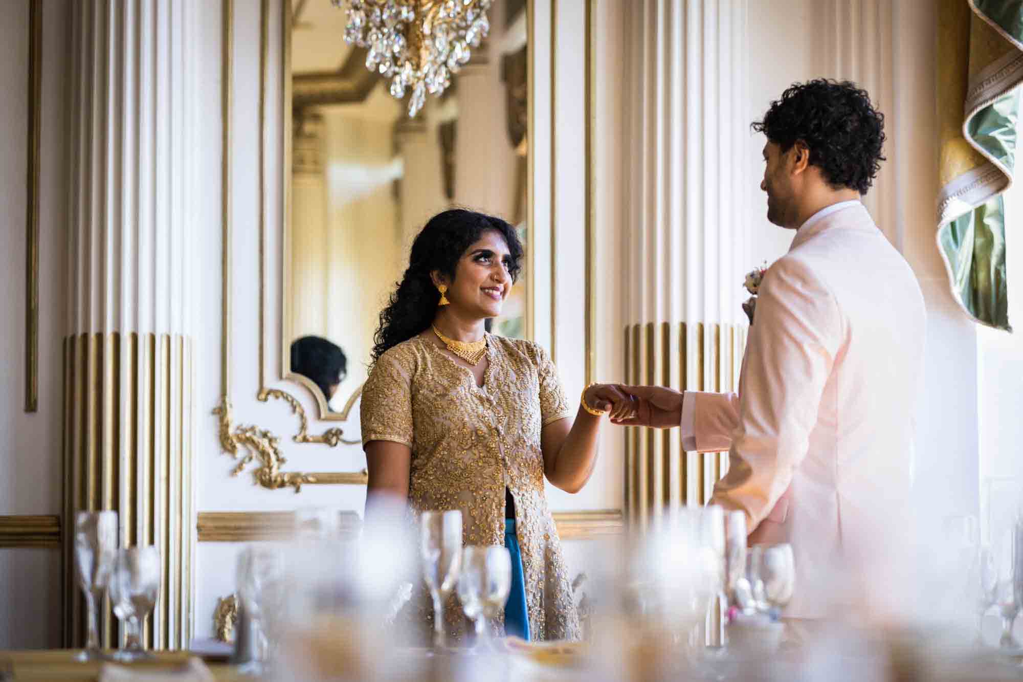 Groom holding hand of Indian bride in front of mirror during a Terrace on the Park wedding