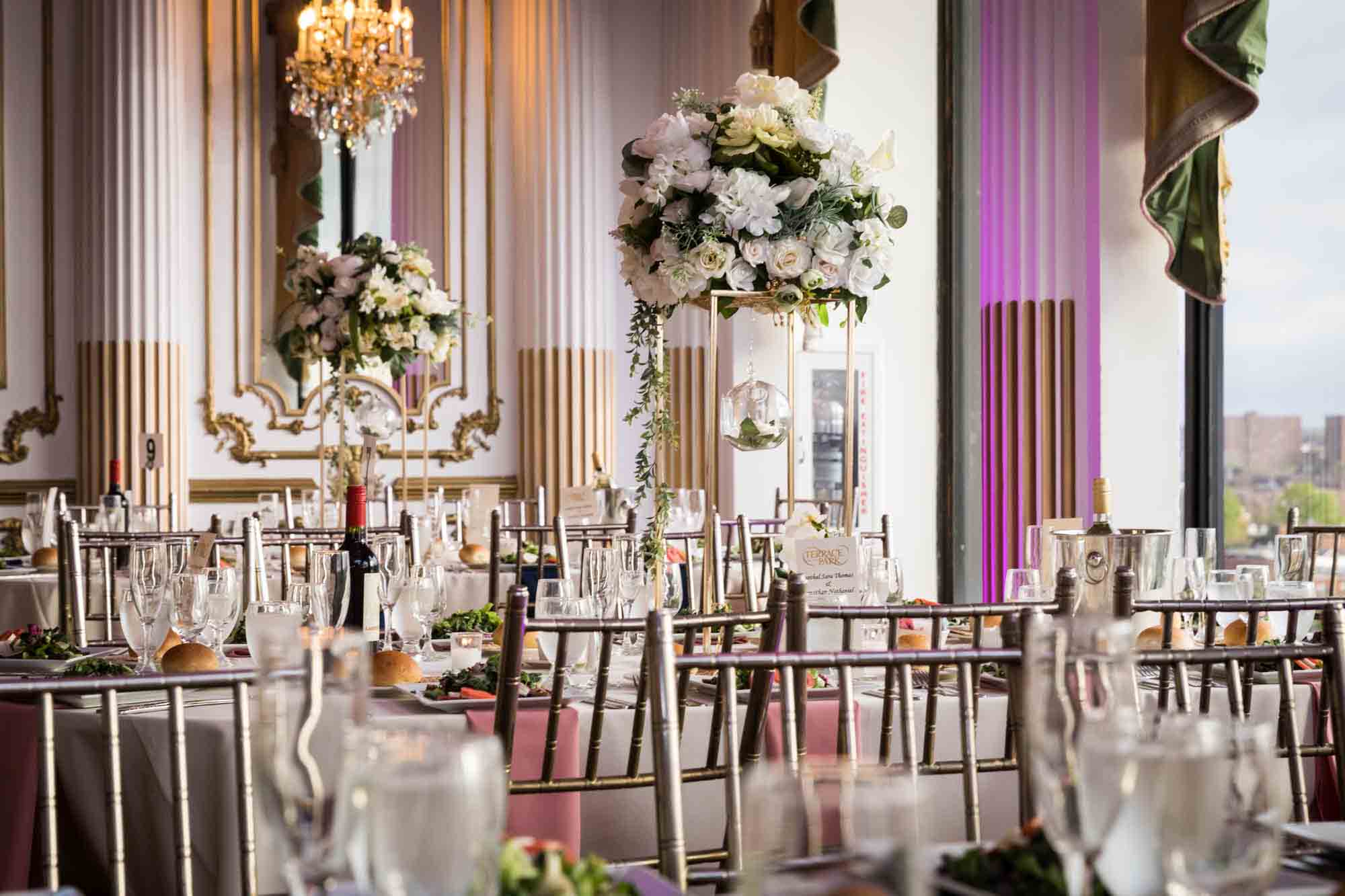 Tables set with glasses and flower centerpieces during a Terrace on the Park wedding