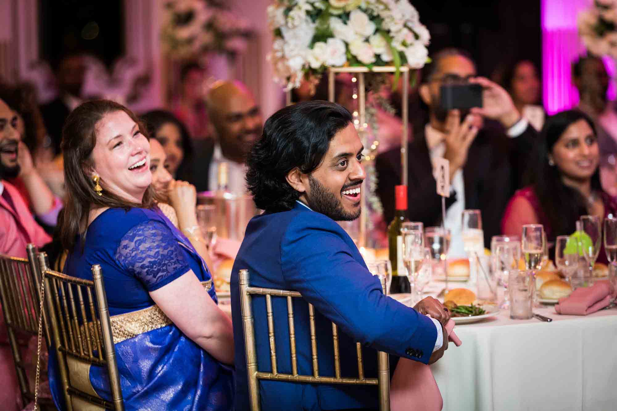 Guests at a table laughing during speeches for an article on Terrace on the Park wedding photo tips