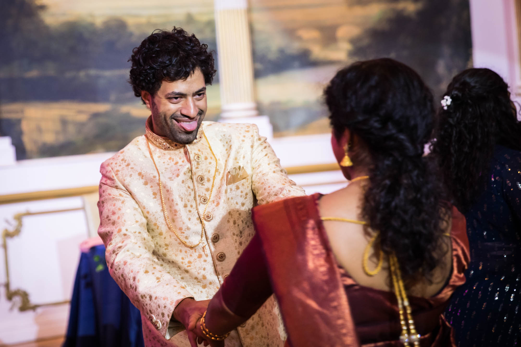 Groom dancing with Indian bride with tongue out for an article on Terrace on the Park wedding photo tips