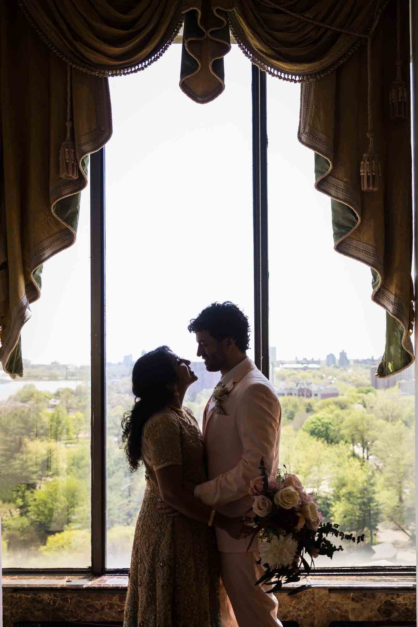 Backlit photo of bride and groom standing in front of window during a Terrace on the Park wedding