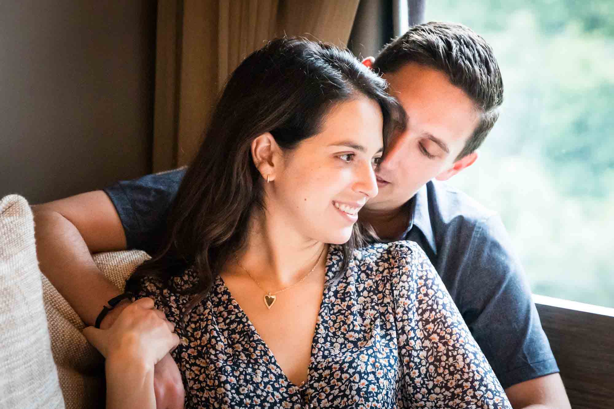 Couple sitting together on couch in front of large window at 1 Brooklyn Bridge Hotel