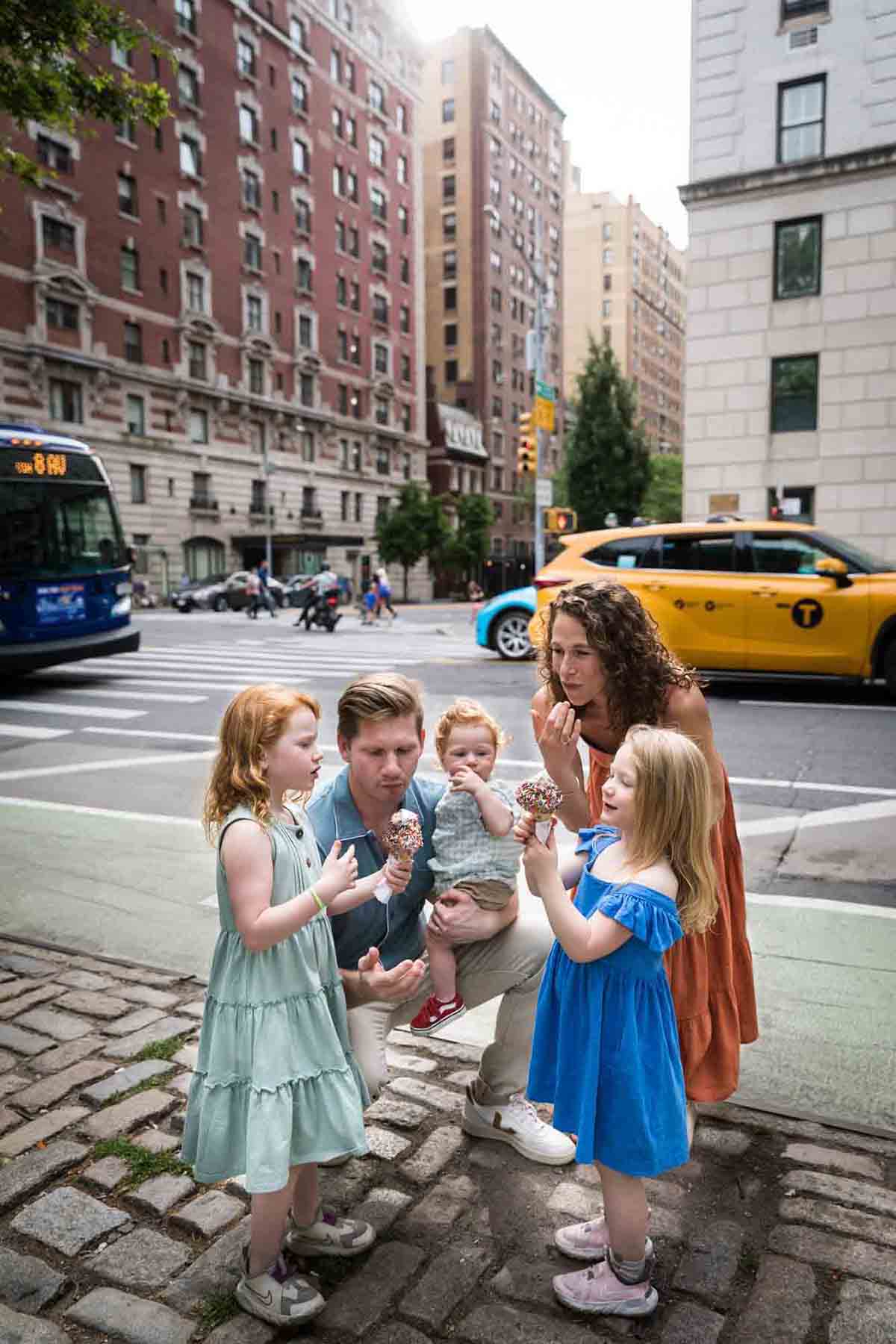 Family eating ice cream on a NYC sidewalk with yellow taxi in background