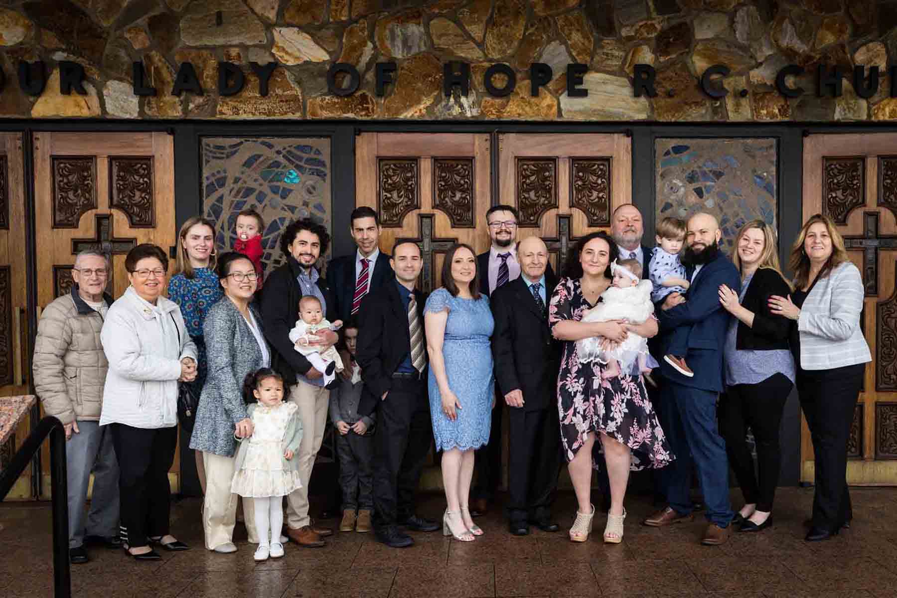 Maspeth baptism photos of large family in front of Our Lady of Hope Roman Catholic Church