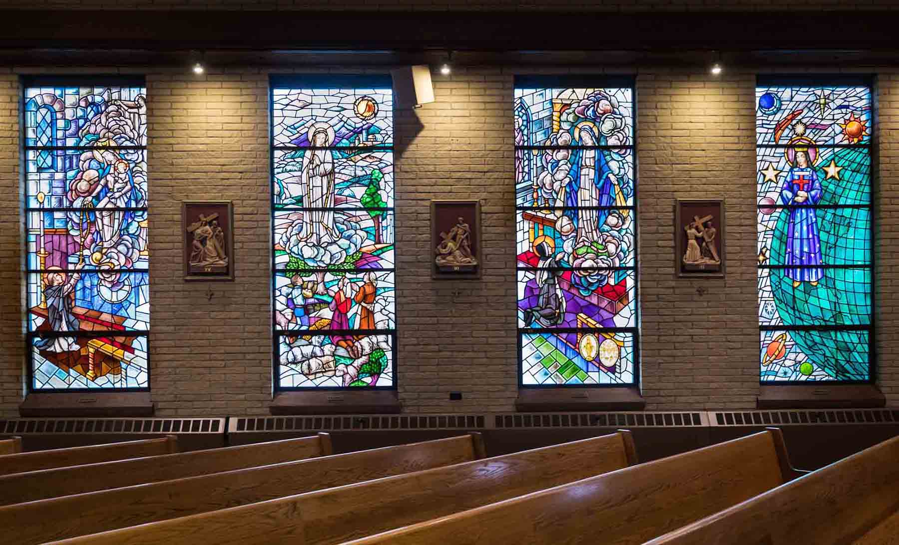 Stained glass windows and pews in Our Lady of Hope Roman Catholic Church