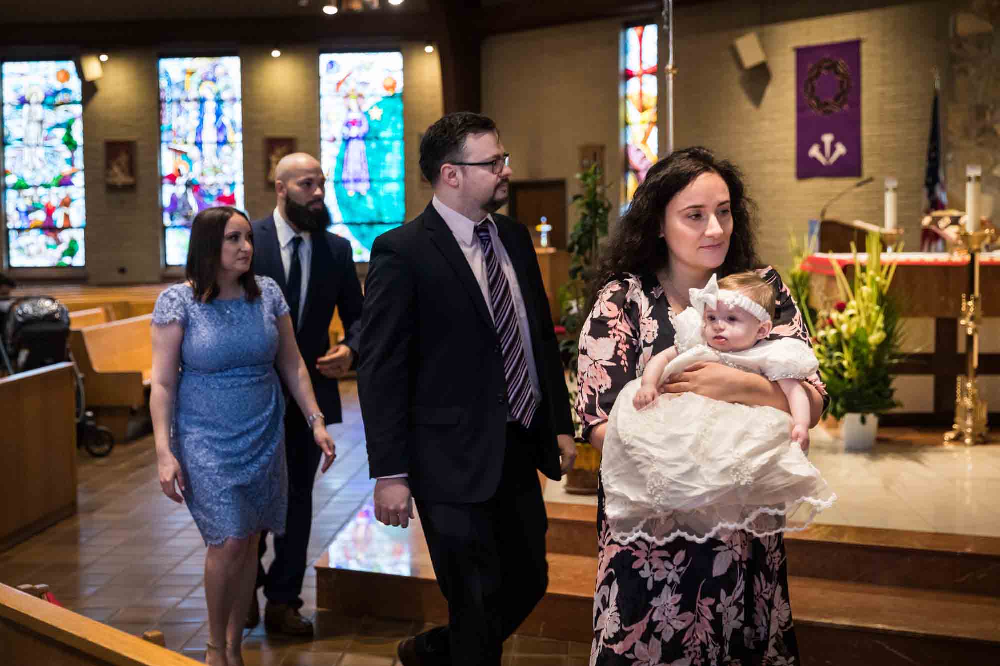 Maspeth baptism photos of mother and family bringing baby to baptismal fount
