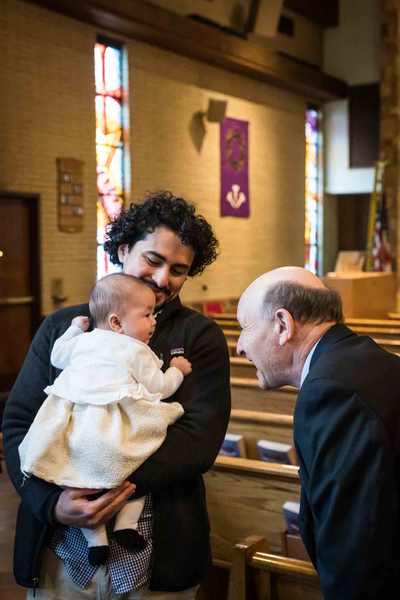 Maspeth baptism photos of father showing baby to grandfather in church