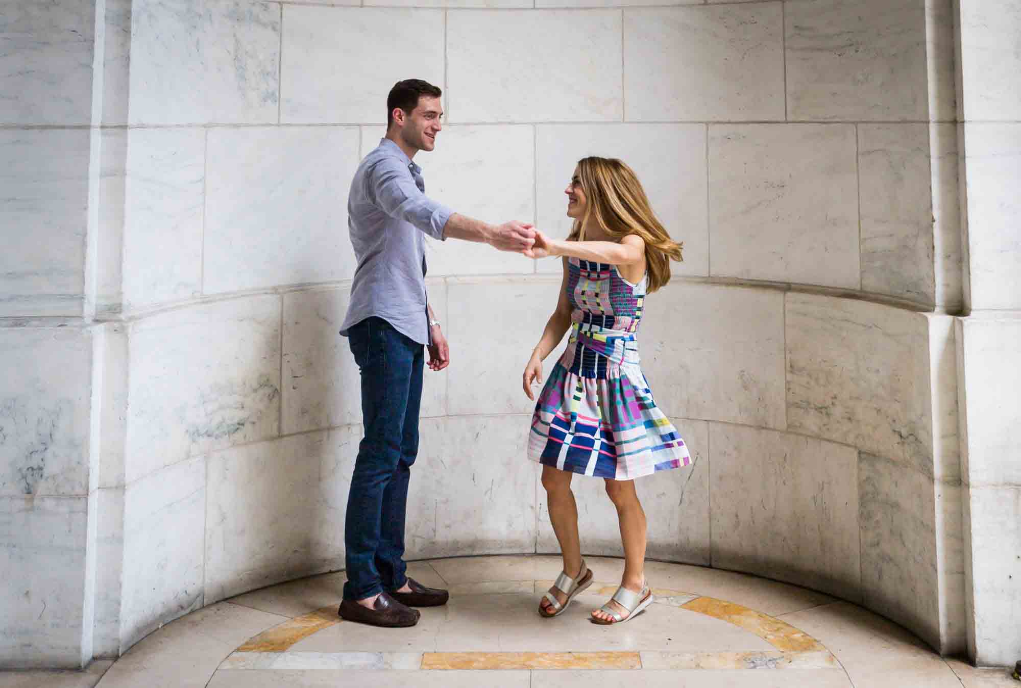 Couple dancing in a marble rotunda during a New York public library engagement photo shoot