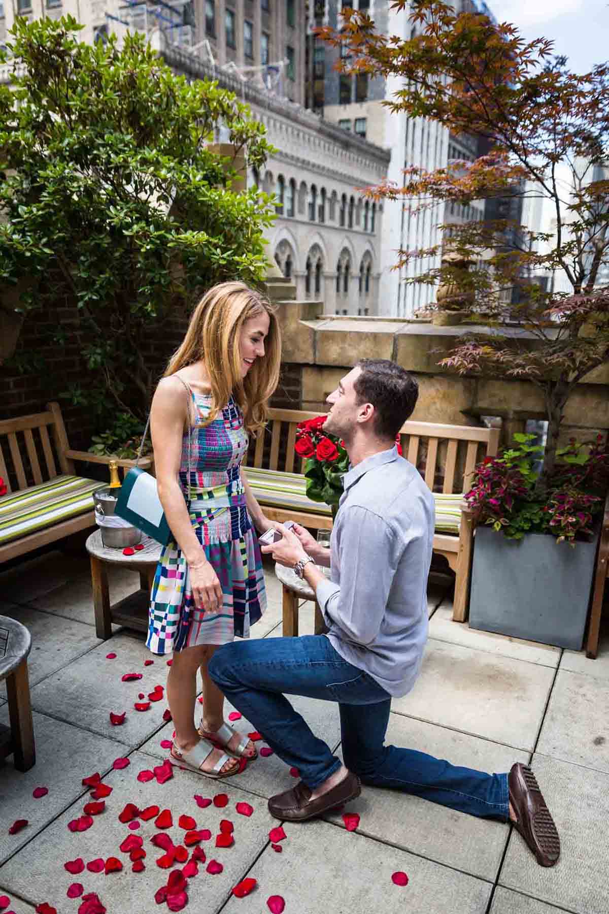 Man on one knee proposing to woman wearing multicolored dress at the Library Hotel
