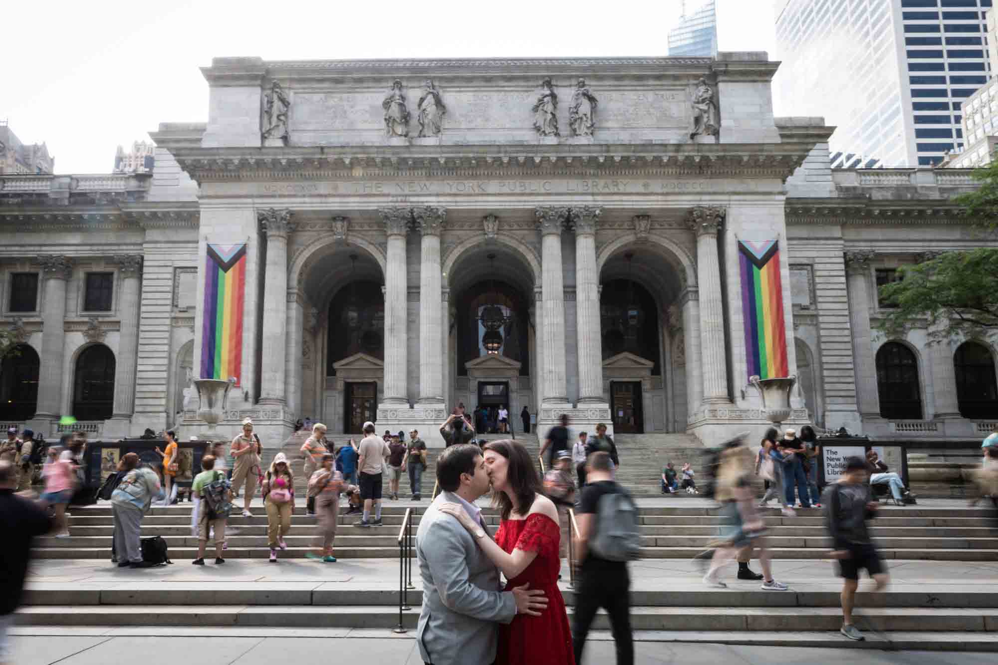 Couple kissing in front of library with people hurrying past after New York Public Library proposal
